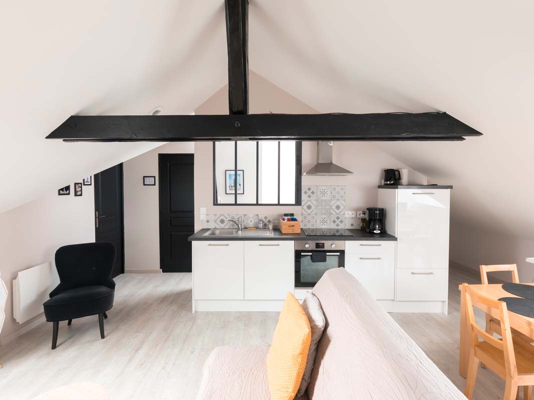 Aménagement appartement sous les toits pour location airbnb. Poutres noires, touches de jaune, ambiance scandinave. Aménagement décoration intérieur Amiens