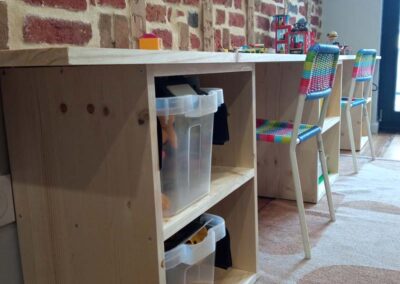 Salle de jeux bureau enfants, chaises multicolores, briques apparentes au mur. Décoratrice d'intérieur Arras Nord Pas De Calais